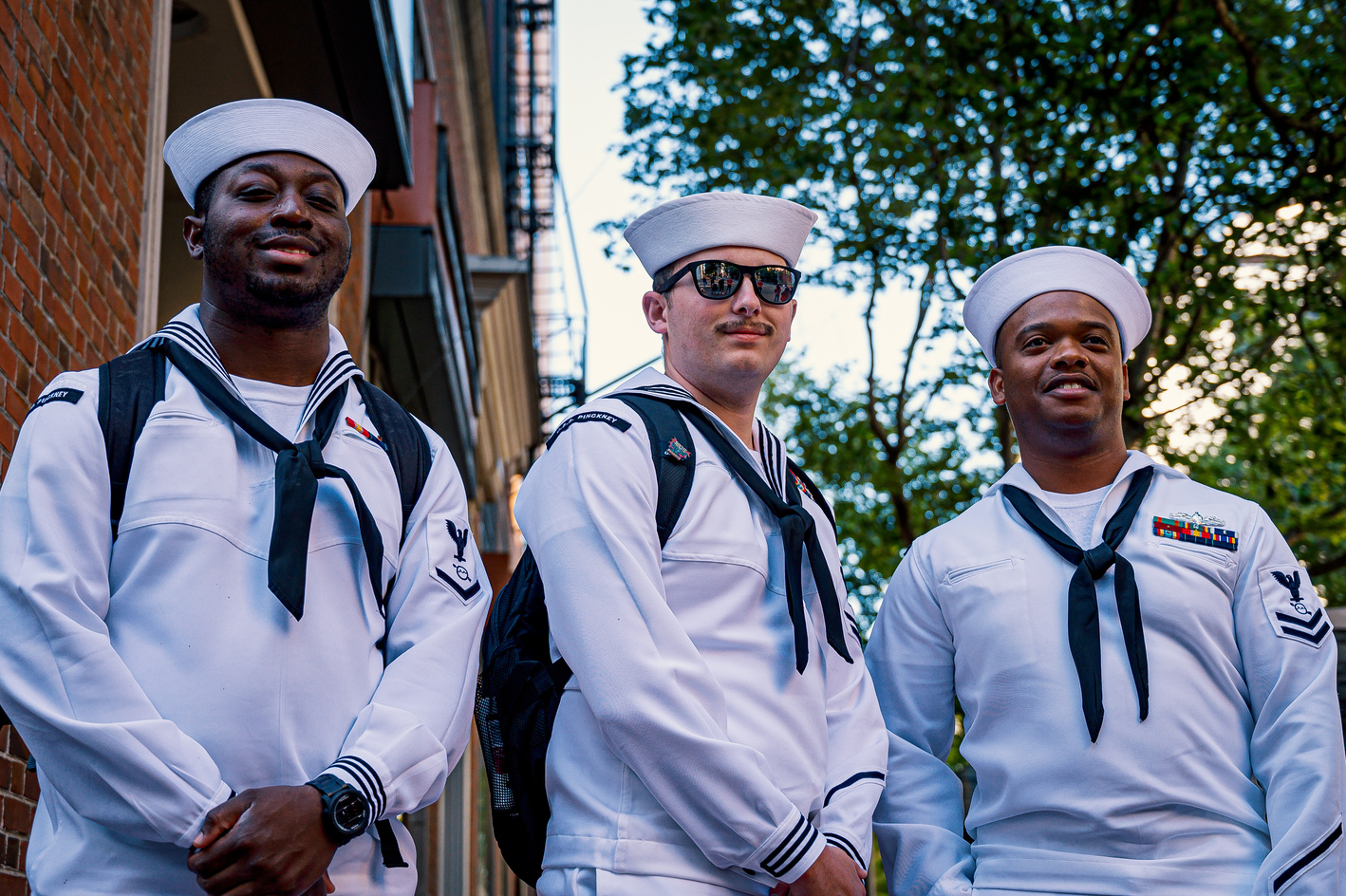Three Men Standing in White Uniform and Smiling